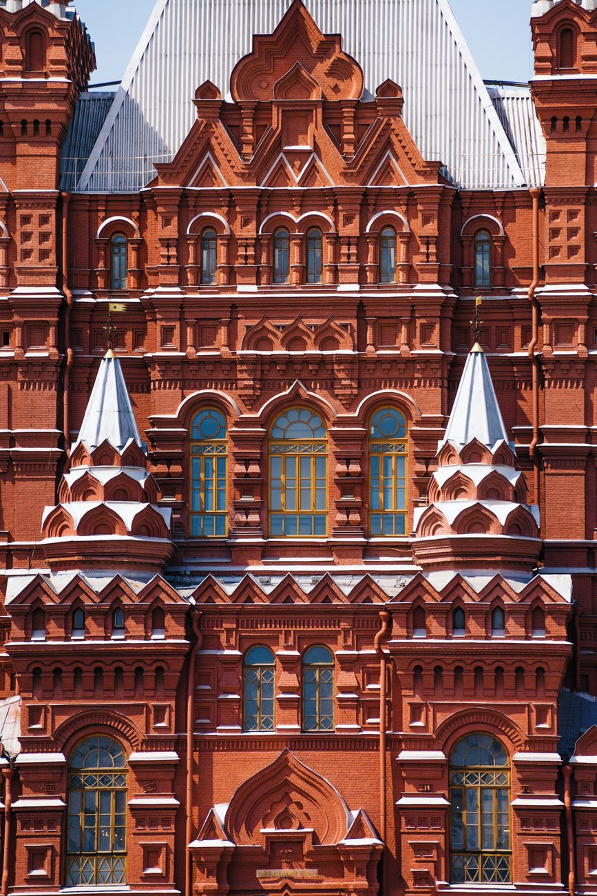 Illuminated facade of the State Historical Museum in Moscow at night.