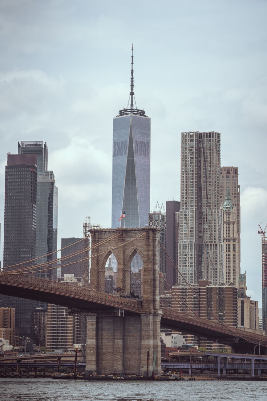 A dramatic view of the skyscrapers of New York City captured from the Brooklyn Bridge.