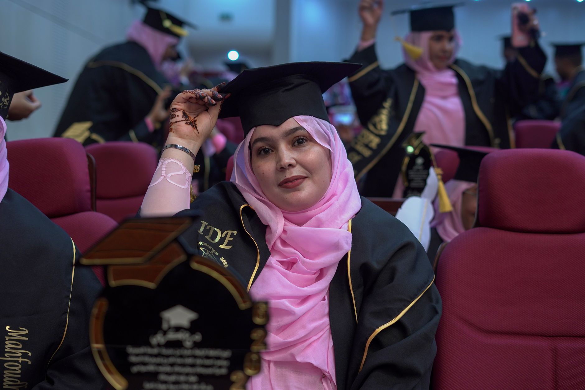 A joyful graduate in cap and gown during the university graduation ceremony.